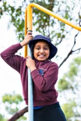 Student outside on the school playground. Sliding down a fireman style pole